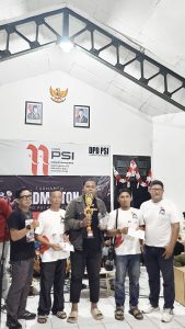 Ketua DPD PSI Kudus Antoni Alfin (kiri) di dampingi Ketua Harian menyerahkan hadiah lomba Badminton dalam rangka HUT RI ke-81